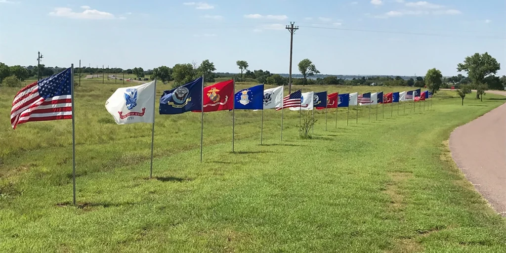 Repeating flags at the entrance to Foss Lake Christmas in July, representing each military branch and the United States flag.
