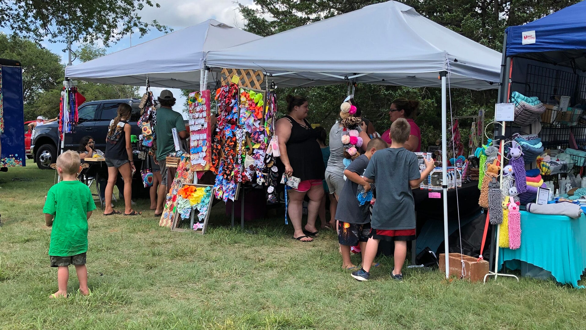 Vibrant vendor booths showcasing a variety of products at Foss Lake Christmas in July event